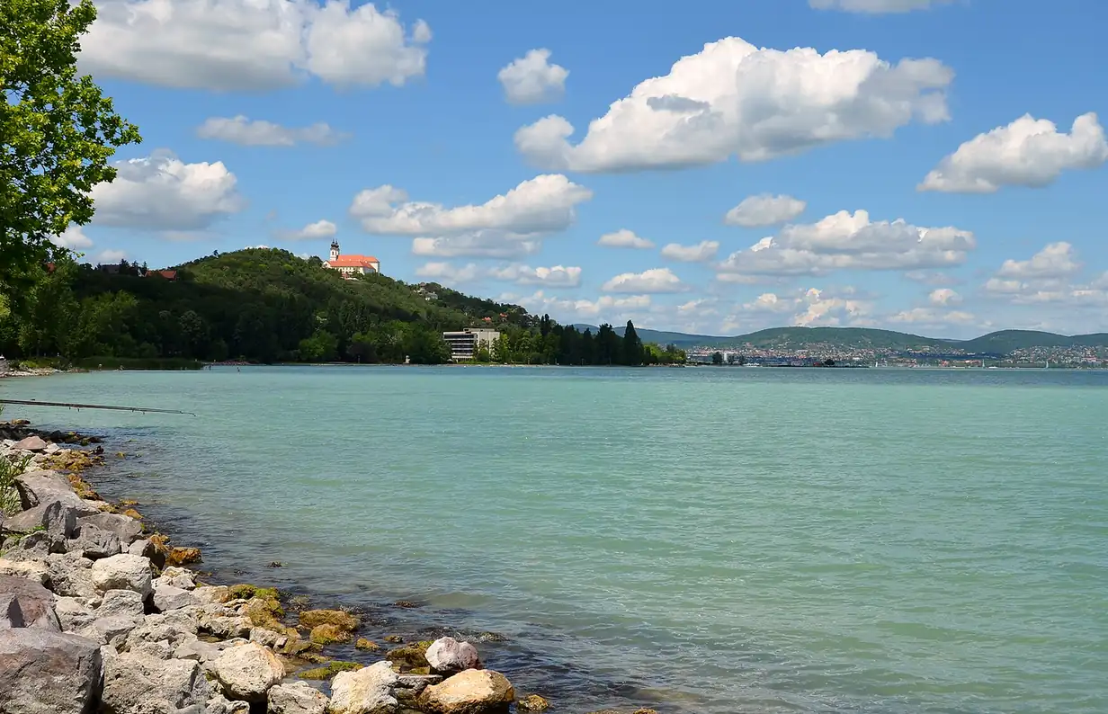 A Balaton türkiz vize köves parttal, a dombon a tihanyi apátság